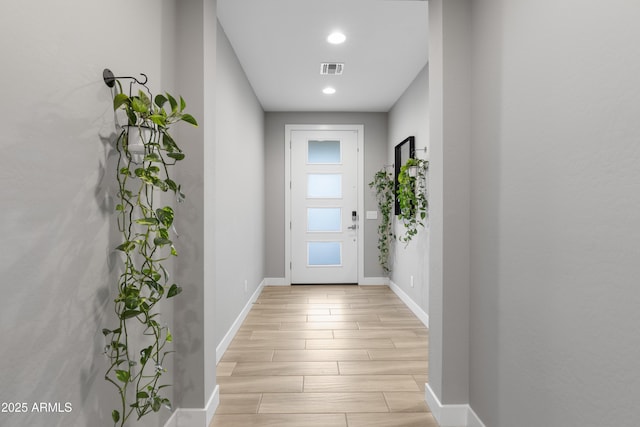 doorway to outside featuring light wood-style flooring, recessed lighting, visible vents, and baseboards