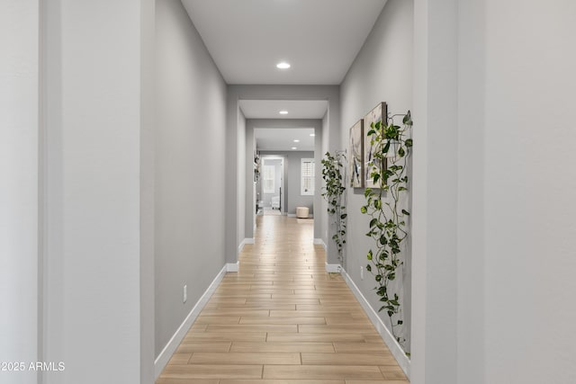 hallway with light wood-style floors, recessed lighting, and baseboards