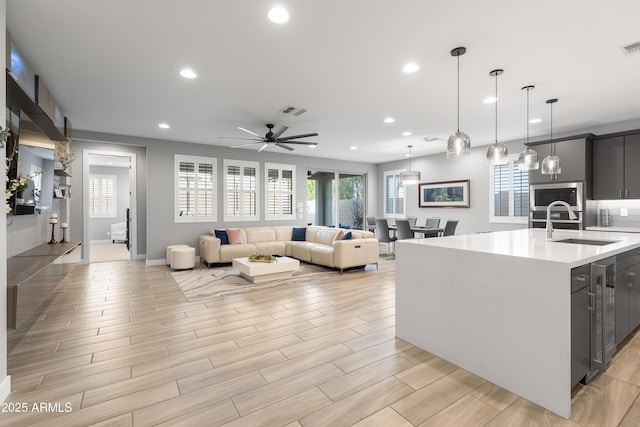 kitchen featuring recessed lighting, light countertops, visible vents, stainless steel microwave, and a sink