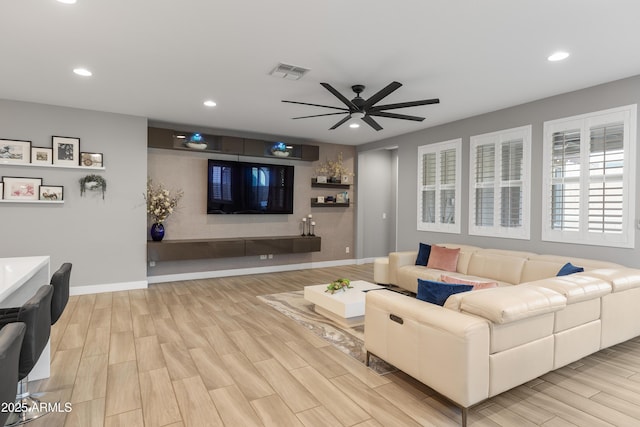 living area with wood tiled floor, visible vents, baseboards, and recessed lighting