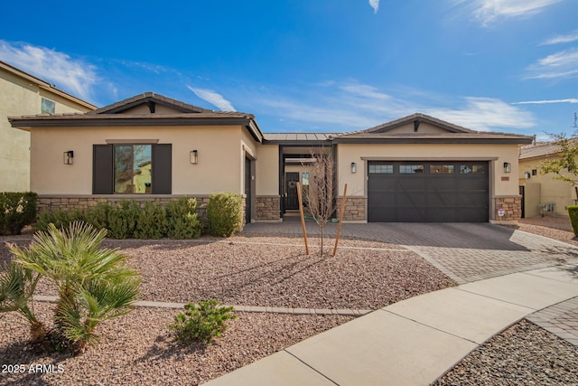 view of front of house with stone siding, an attached garage, and stucco siding