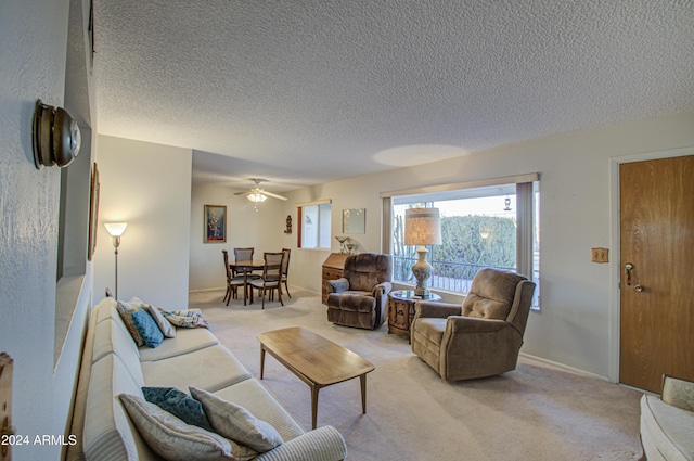 living room featuring light carpet, ceiling fan, and a textured ceiling