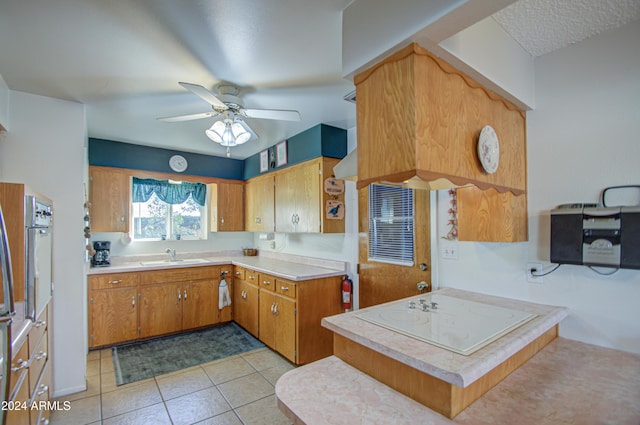 kitchen with ceiling fan, sink, kitchen peninsula, oven, and light tile patterned flooring