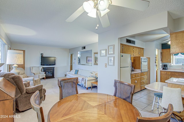 carpeted dining room featuring ceiling fan and a textured ceiling