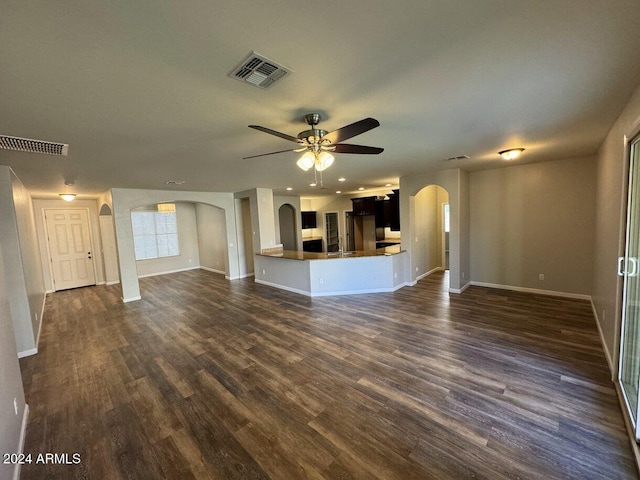 unfurnished living room with ceiling fan and dark wood-type flooring