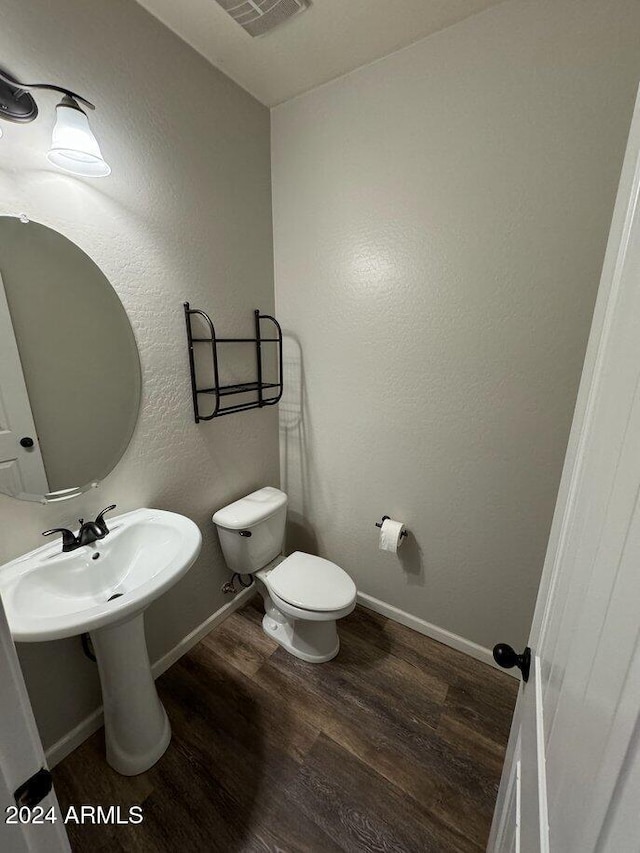 bathroom with toilet and wood-type flooring