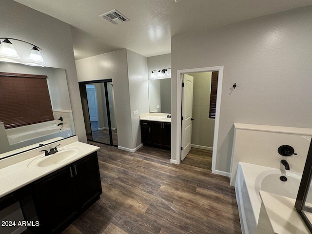 bathroom featuring vanity, hardwood / wood-style flooring, and a bathtub