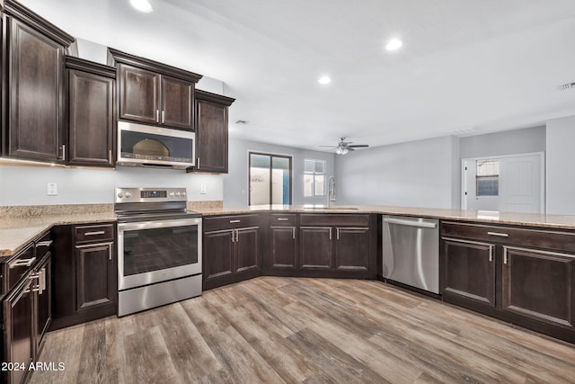 kitchen with dark brown cabinetry, ceiling fan, sink, appliances with stainless steel finishes, and light wood-type flooring