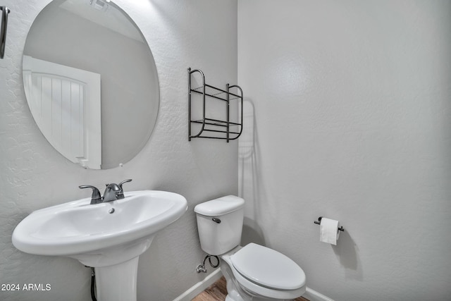 bathroom featuring toilet, wood-type flooring, and sink