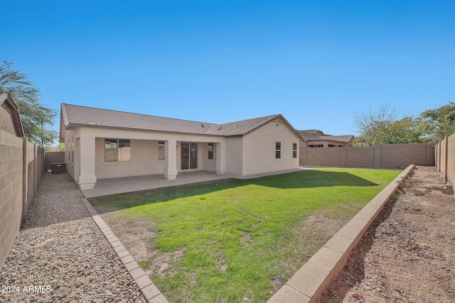 back of house featuring a lawn and a patio area