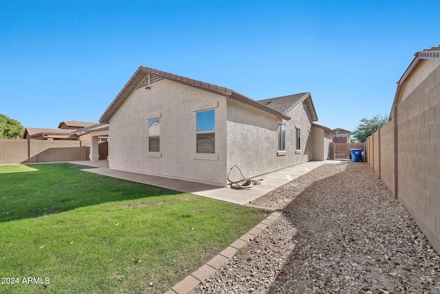 back of property featuring a patio area and a yard