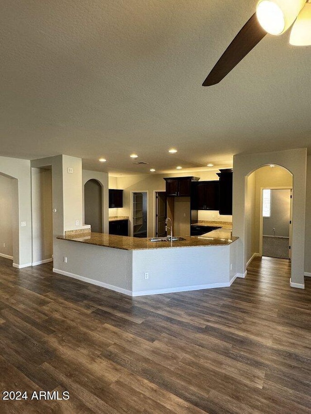 kitchen with kitchen peninsula, ceiling fan, dark hardwood / wood-style flooring, and sink