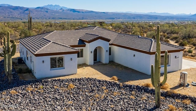 view of front of house with a mountain view and central AC