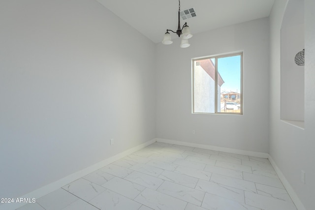 spare room with lofted ceiling and an inviting chandelier