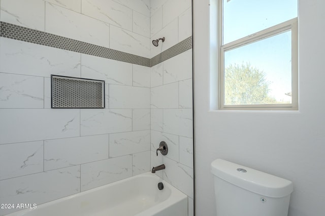 bathroom with toilet and tiled shower / bath