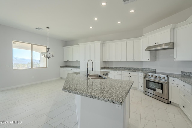 kitchen with light stone countertops, sink, high end stove, a kitchen island with sink, and white cabinets