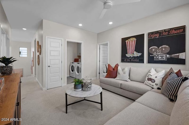 living room featuring washer and dryer, light carpet, and ceiling fan