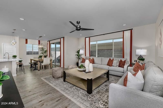 living room with light wood finished floors, a ceiling fan, and recessed lighting