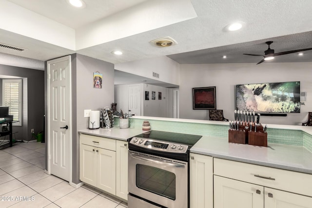 kitchen featuring stainless steel range with electric cooktop, light countertops, a textured ceiling, light tile patterned floors, and visible vents