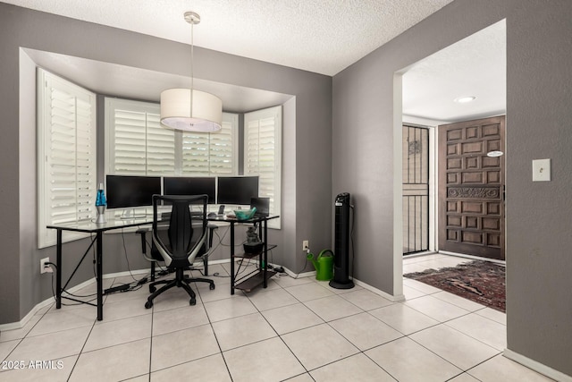 tiled office space with baseboards and a textured ceiling