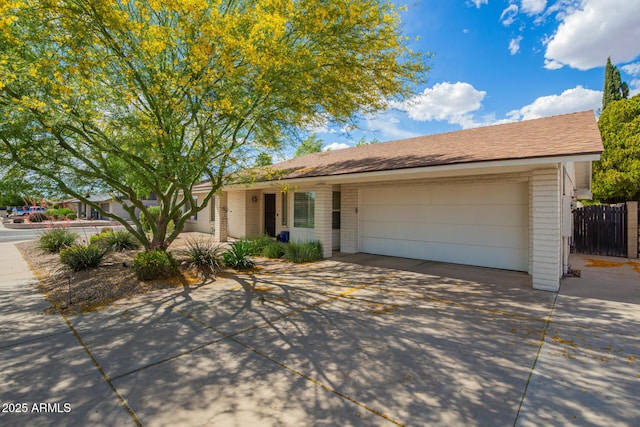 ranch-style house featuring brick siding, a garage, fence, and driveway