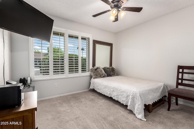 bedroom with a textured ceiling, baseboards, and carpet