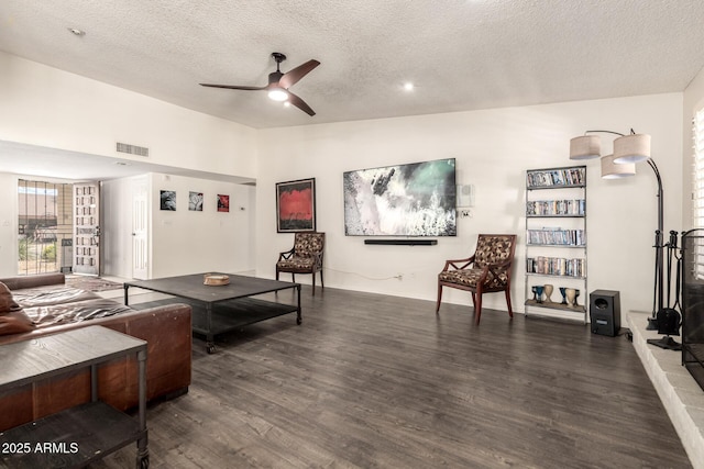 living area featuring visible vents, wood finished floors, ceiling fan, a textured ceiling, and vaulted ceiling