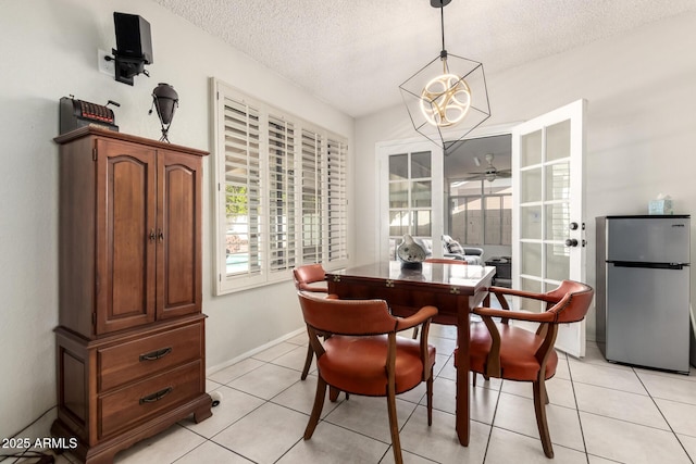dining room with baseboards, a textured ceiling, ceiling fan, and light tile patterned floors