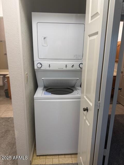 clothes washing area with stacked washer / dryer