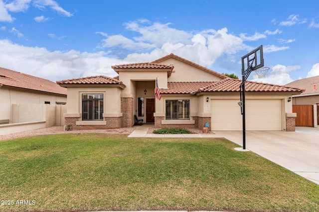 mediterranean / spanish house with brick siding, concrete driveway, a front yard, stucco siding, and an attached garage