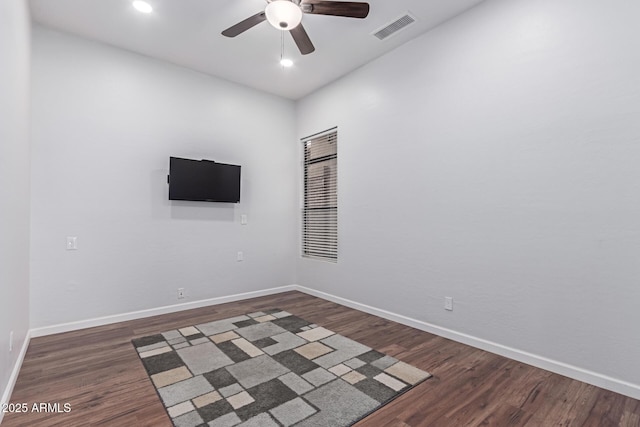 spare room with visible vents, baseboards, ceiling fan, and dark wood-style flooring