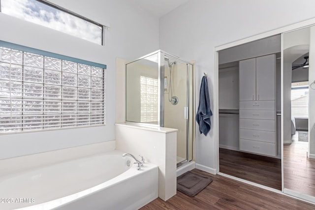 bathroom with wood finished floors, a shower stall, and a bath