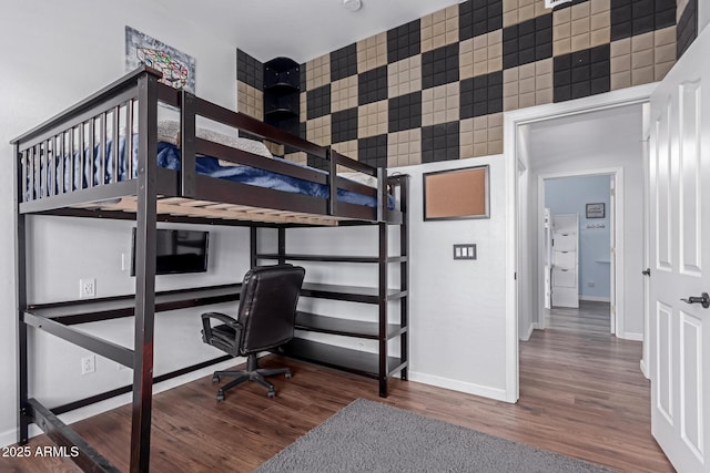 bedroom featuring baseboards and wood finished floors