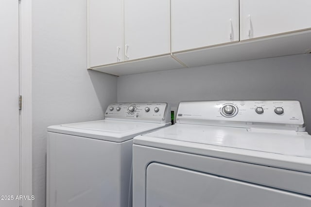 washroom with cabinet space and washing machine and clothes dryer