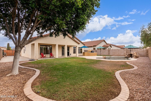 back of house featuring stucco siding, a lawn, a fenced backyard, and a patio area