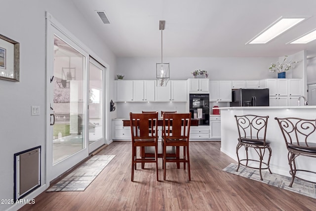 dining area featuring visible vents and wood finished floors