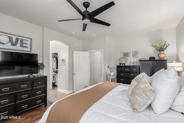 1324 S Banning St, Gilbert, AZ 85296 - bedroom with arched walkways, a spacious closet, wood finished floors, a closet, and a ceiling fan