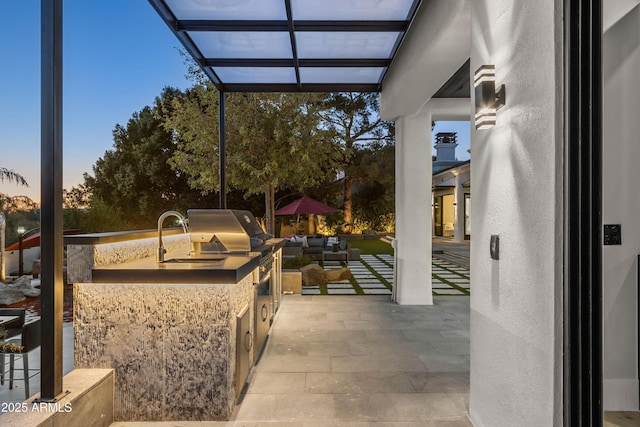 patio terrace at dusk featuring a lanai, grilling area, and area for grilling