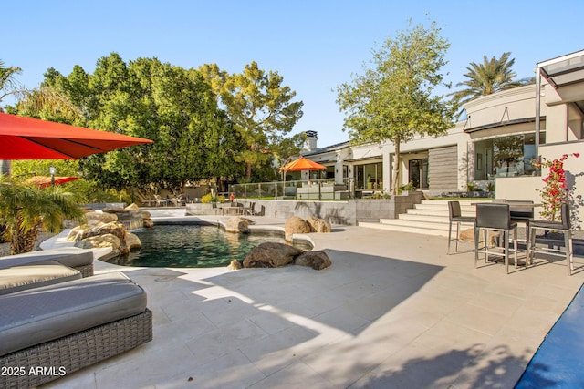 view of patio with an outdoor pool and fence