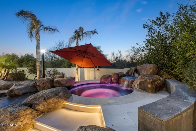 view of pool featuring fence and an in ground hot tub