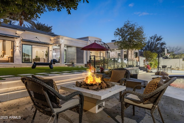 view of patio with an outdoor fire pit and fence