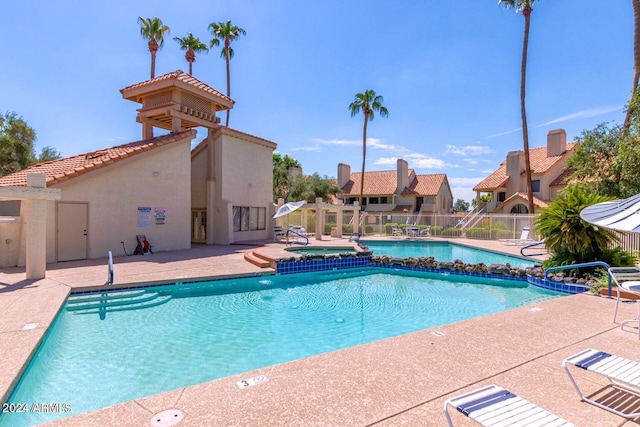 view of swimming pool featuring a community hot tub and a patio area