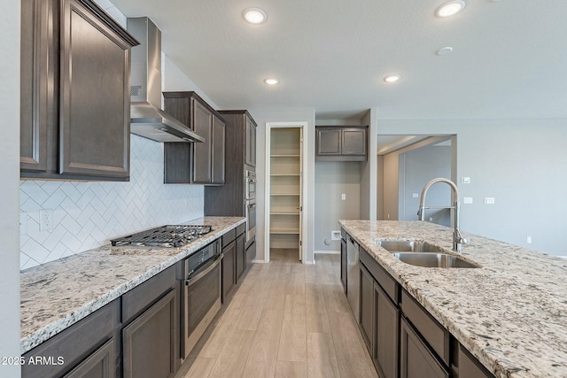 18766 W Montebello Ave, Litchfield Park, AZ 85340 - kitchen featuring light stone counters, a sink, wall chimney exhaust hood, and stainless steel appliances