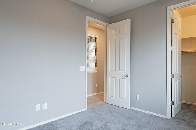 18766 W Montebello Ave, Litchfield Park, AZ 85340 - unfurnished bedroom featuring a closet, baseboards, a spacious closet, and carpet