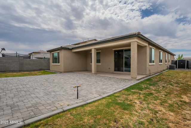 18766 W Montebello Ave, Litchfield Park, AZ 85340 - rear view of house featuring a patio, stucco siding, central AC unit, a yard, and fence