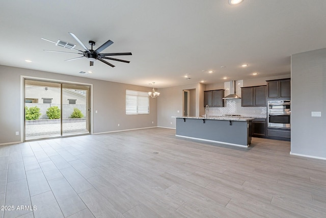 18766 W Montebello Ave, Litchfield Park, AZ 85340 - kitchen with a breakfast bar, open floor plan, stainless steel double oven, visible vents, and wall chimney exhaust hood