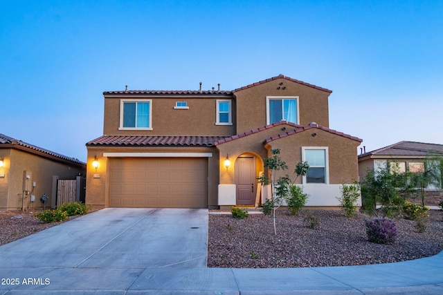 mediterranean / spanish house featuring stucco siding, driveway, a tile roof, a garage, and fence