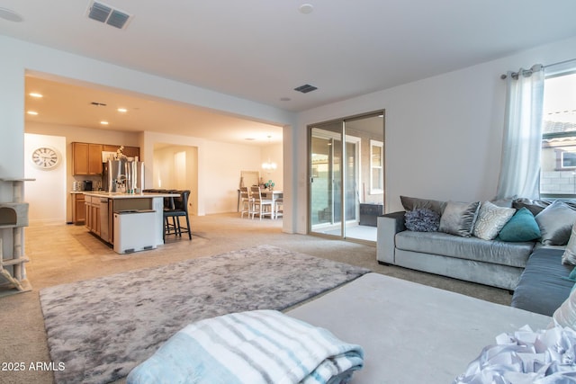 living area featuring light carpet, a chandelier, and recessed lighting