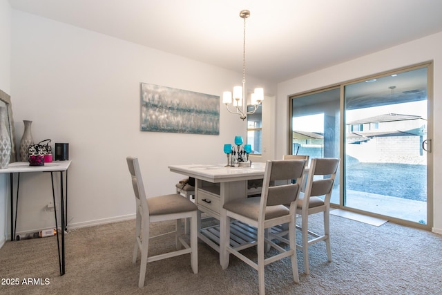 carpeted dining room with a chandelier and baseboards