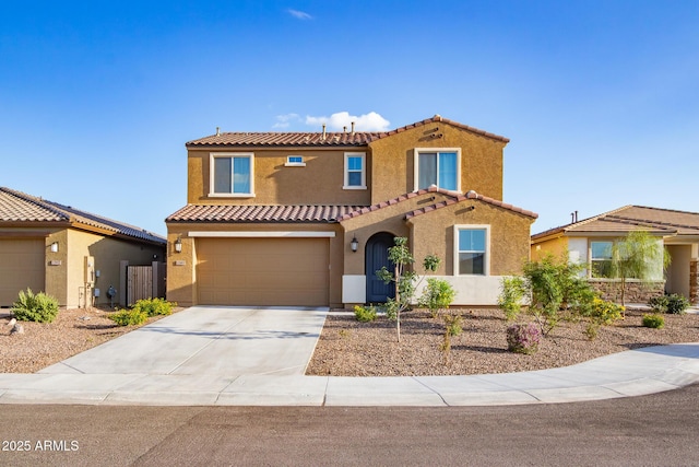 mediterranean / spanish-style home with stucco siding, a tiled roof, an attached garage, and driveway